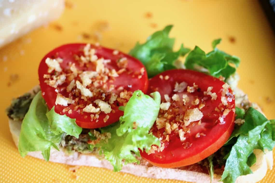 Tomato sandwich topped with toasted breadcrumbs.