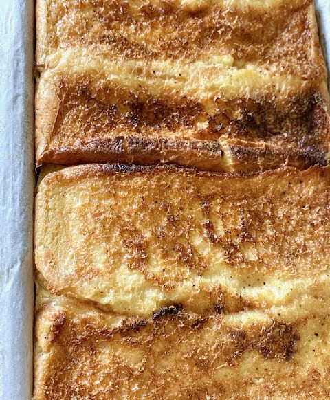 Baked bread pudding in a loaf pan.