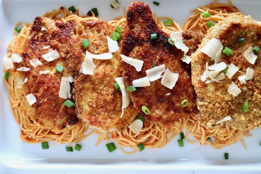 Breaded pork chops on pasta.