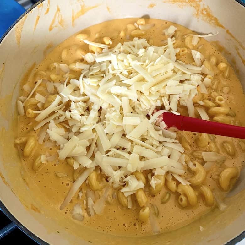 Mixing cheese and pasta and sauce.
