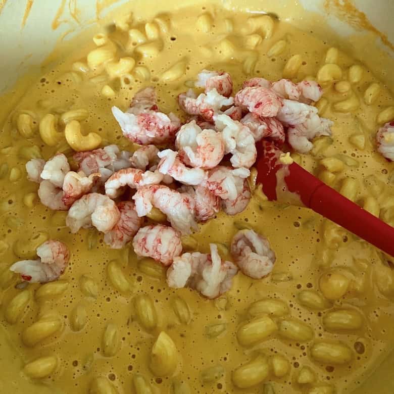 Adding lobster to the dish.