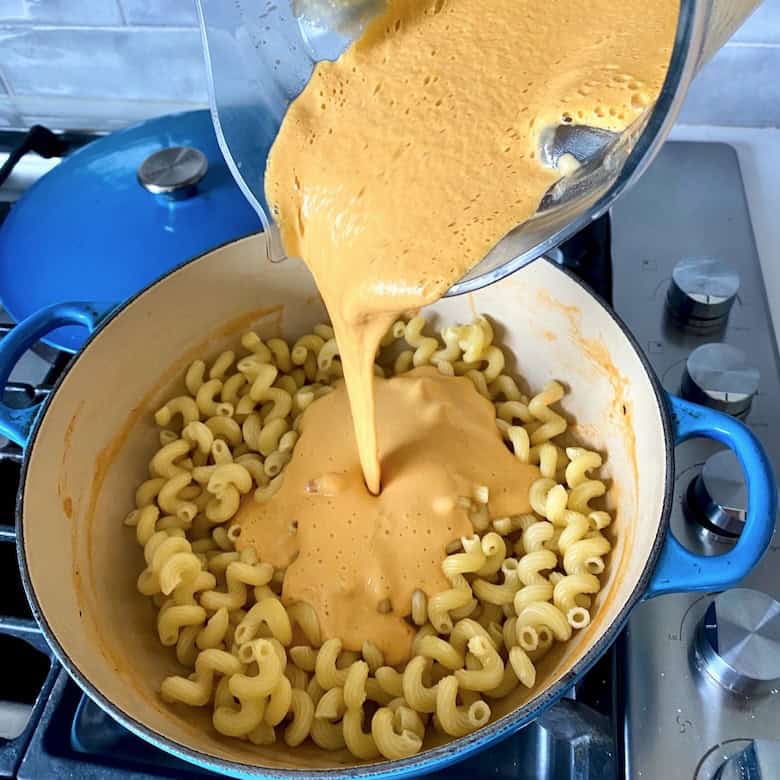 Mixing cooked pasta and lobster sauce.