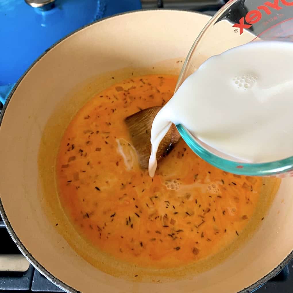 Adding milk to the lobster sauce.