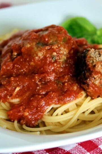 Plate of spaghetti and fried Italian meatballs.