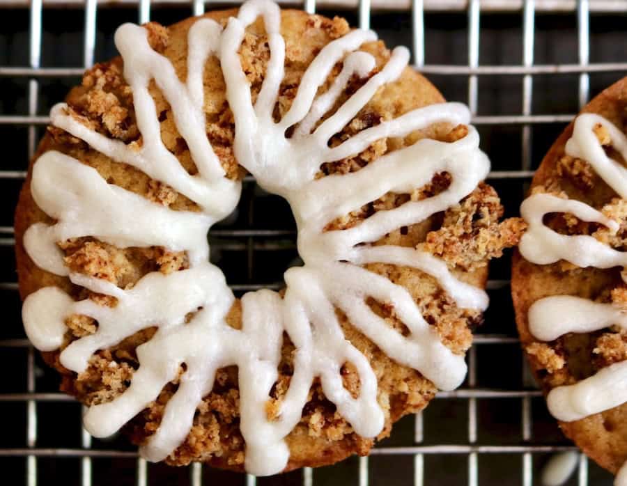 Donuts with icing on top of a cooling rack.
