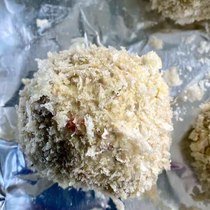 A panko crusted croquette on foil.