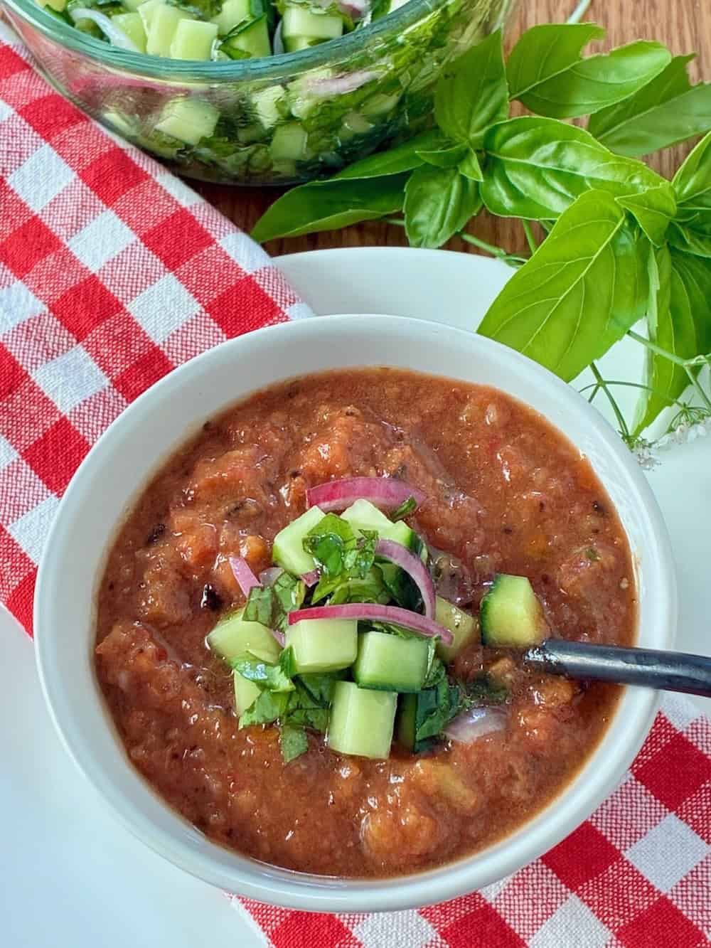 Chilled gazpacho soup garnished with vegetables.