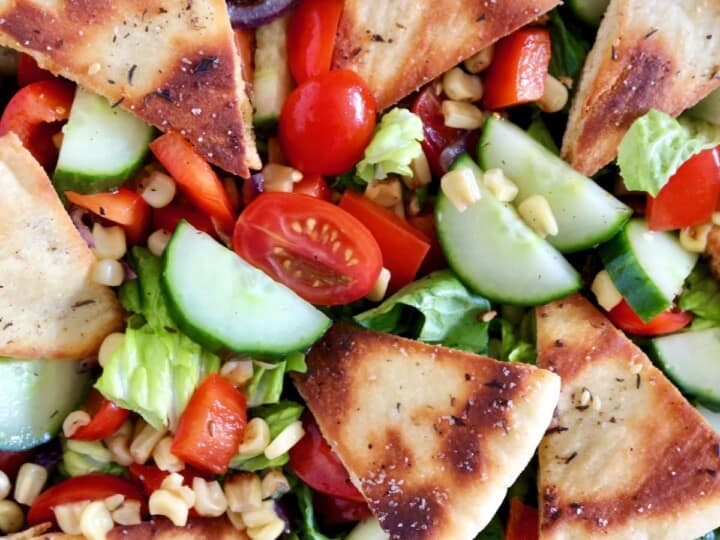 An Israeli salad with pita bread slices and vegetables.