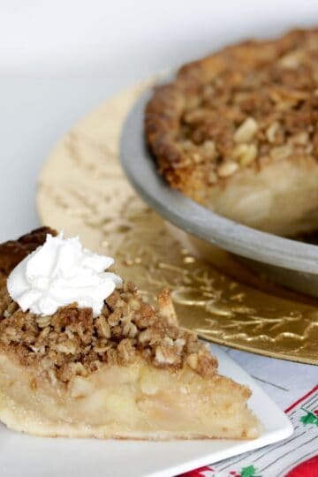 Delicious apple crumb pie topped with crunchy streusel and whipped cream, perfect for holidays or cozy gatherings.
