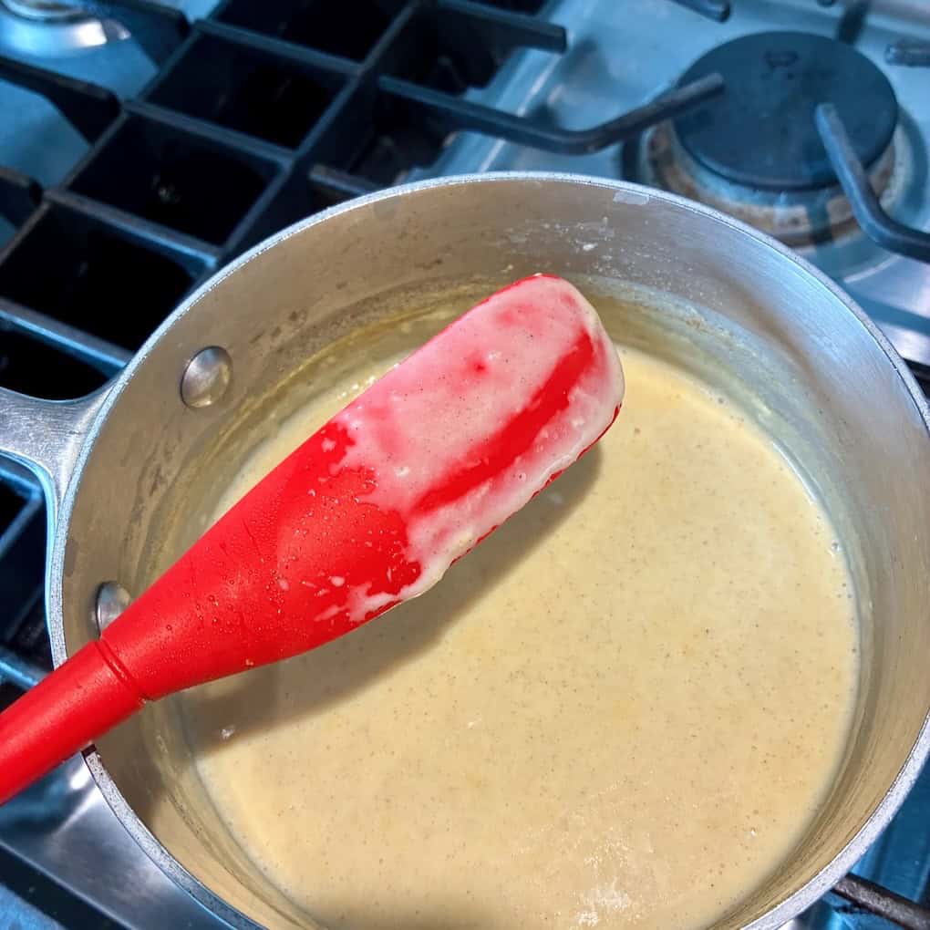 Testing custard for thickness on the back of a spatula.