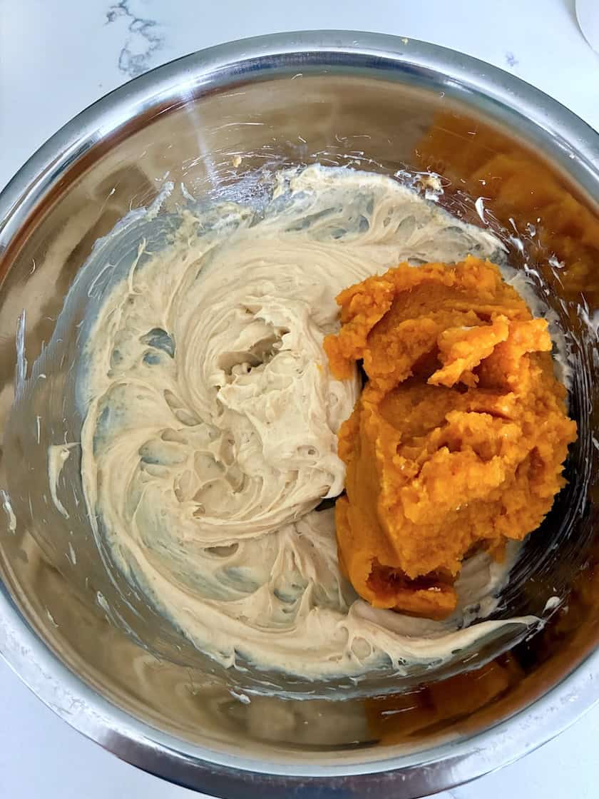 Mixing pumpkin cheesecake filling in a bowl.