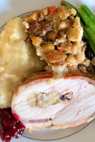 Plate with turkey, mashed potatoes, green beans, stuffing, and cranberry sauce.